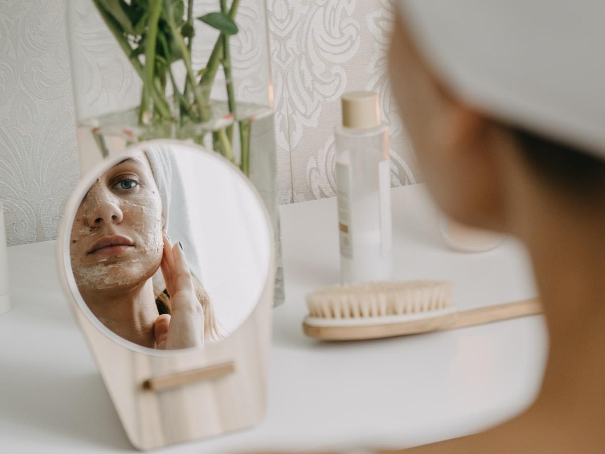 Woman applying clay face mask
